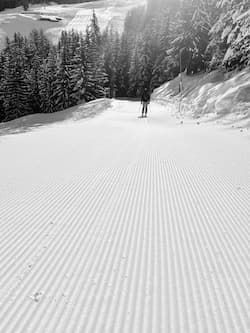 Skier on a freshly groomed slope in Pila