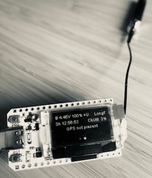 A Heltec v3 board with antenna showing the Meshtastic node info on its display