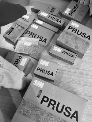 Someone pointing at a floor full of Prusa boxes